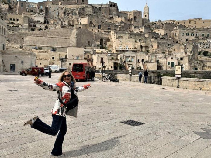 A woman in a sari poses for a photo in front of the iconic landmark.. She is smiling proudly, clearly happy to be visiting this iconic landmark.